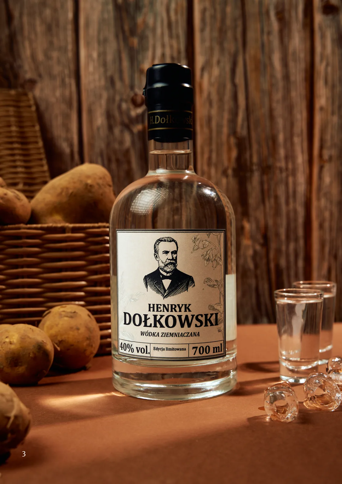 Butelka Henryk Dołkowski na tle drewna, obok kosz ziemniaków